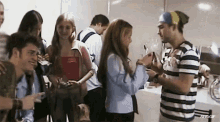 a man in a striped shirt is talking to a girl in a crowd