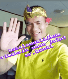a man wearing a crown and a yellow shirt says " assalamualaikum " in purple letters