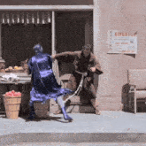 a man in a purple robe is fighting another man in front of a sign that says kingston