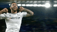 a soccer player wearing a white shirt that says avon