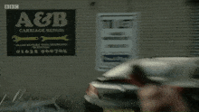 a woman is using a cell phone in front of a sign that says a & b