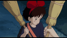 a little girl with a red bow on her head is holding a broom