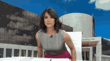 a woman stands in front of a building that says ' la castilla y leon '