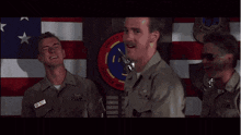 three men in military uniforms are standing in front of a united states flag