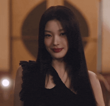 a woman with long black hair and red lipstick is looking at the camera