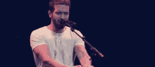 a man singing into a microphone while playing a keyboard