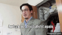 a man in a suit and glasses is standing in a closet and says awfuck not this bullshit again