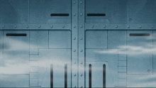 a blue metal wall with holes in it and a cloudy sky in the background