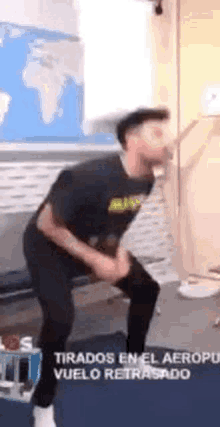 a man in a black shirt is standing in a waiting room .