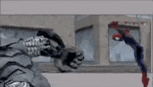 a man in a spiderman costume is fighting a robot in a video game .