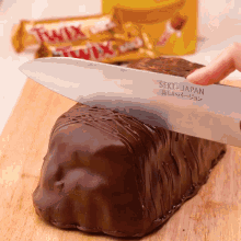 a person is cutting a piece of cake with a knife made in japan