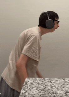 a man wearing headphones is standing on a granite counter top