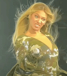 a woman in a camouflage dress holds a microphone in her hand