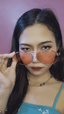 a woman wearing a pair of pink sunglasses