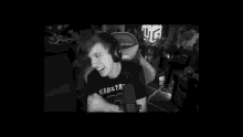 a man is sitting in a gaming chair and laughing while wearing headphones .