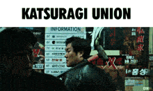 a man holding a hammer stands in front of a sign that says katsuragi union