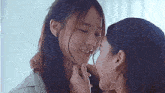 a couple of women are kissing each other on the cheek .