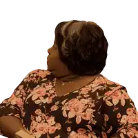 a woman wearing a floral shirt and necklace looks to the side