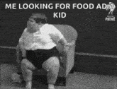 a black and white photo of a fat child sitting on a chair .