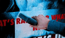 a person is holding a vacuum cleaner over a sign that says " what 's really going on "