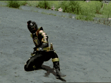 a power ranger is kneeling down in the dirt with a red light behind him
