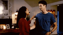 a man and woman are standing next to each other in a living room .
