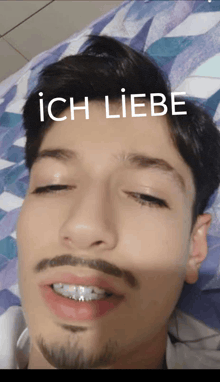a man with braces on his teeth is laying on a bed with the words ich liebe written on his face