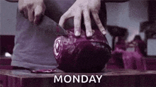 a person is cutting a purple cabbage on a cutting board with a knife .