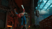 a spider man is hanging upside down while holding a torch