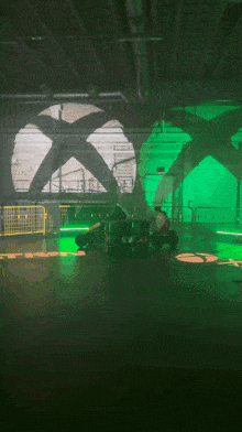 a person sitting in a dark room with green lights