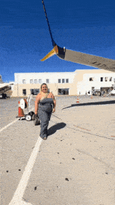 a woman standing in front of an airplane with a wing that says ' united airlines ' on it