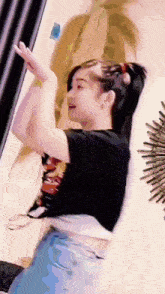 a woman is dancing in a room with her arms outstretched .