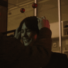 a woman with a cherry on her head is smiling in a dark room
