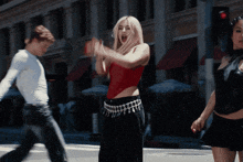 a woman in a red top and black pants is dancing
