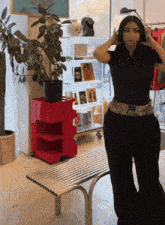 a woman in a black shirt and black pants stands in front of a sign that says ace gallery