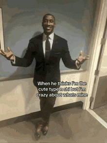 a man in a suit and tie is standing in a doorway with his arms outstretched
