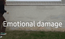 a person walking in front of a wall with the words emotional damage written on it