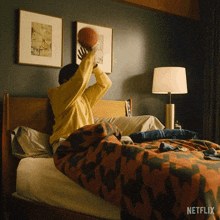 a person is sitting on a bed with a netflix logo on the bottom