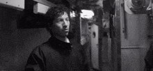 a black and white photo of two men talking