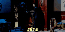 a person standing in a dark room with #bye in yellow letters