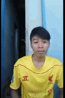 a young man wearing a yellow shirt that says lfc on it