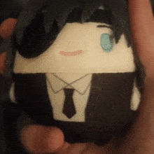 a person is holding a stuffed animal that looks like a man in a suit