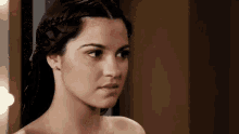 a close up of a woman 's face with a braided hairstyle