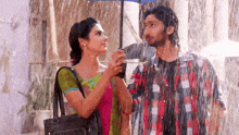 a man and a woman are holding an umbrella in the rain