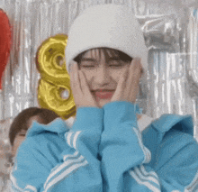 a person wearing a blue jacket and a white beanie is making a face .