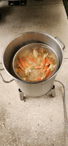 crab legs are being cooked in a stainless steel pot on a stove