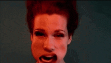 a close up of a woman 's face with her mouth open