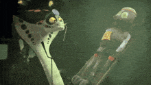 a cartoon character is talking to another cartoon character who is wearing a helmet that says ' a ' on it
