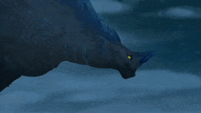 a blue and black dragon with a yellow eye is swimming in the water .