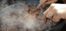 a person is holding a fork over a pot of food